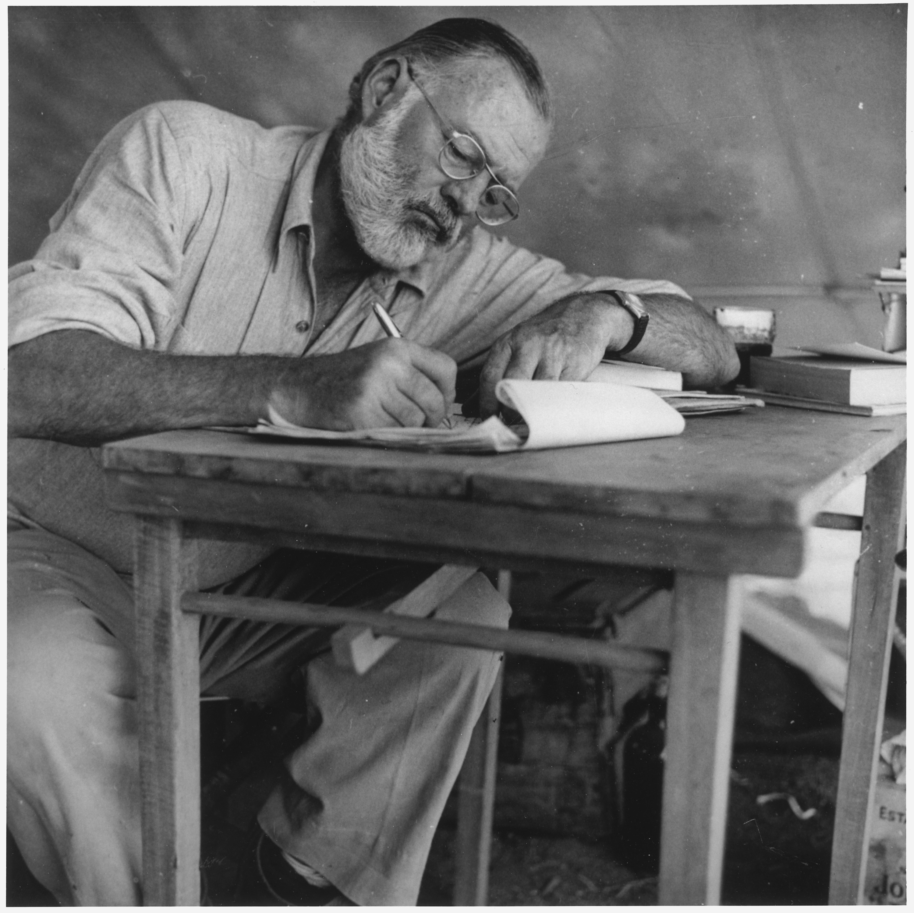 Ernest_Hemingway_Writing_at_Campsite_in_Kenya_-_NARA_-_192655